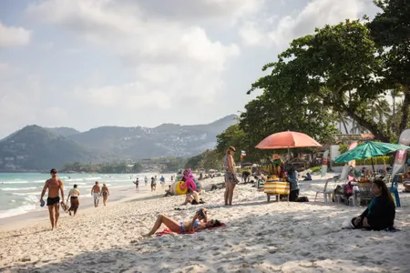 Tourists sunbathe on Chaweng Beach on Koh Samui&#39;s eastern coast.
