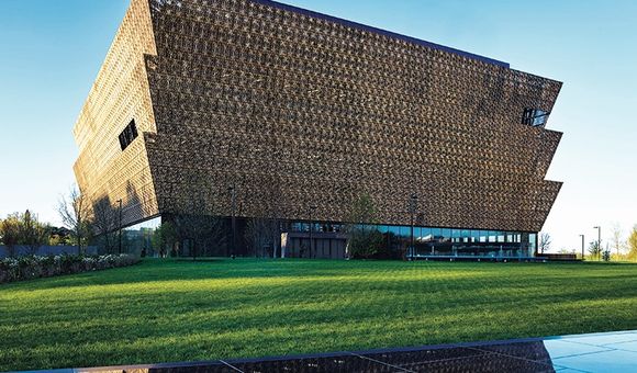 Wrapped in an ornamental bronze latticework, the angular lines of the Museum rise in stark contrast to the rich green landscape.