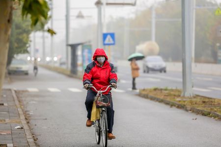 A cyclist braves Beijing's smog with a face mask last month. 