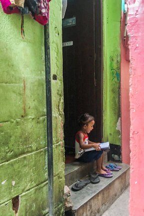 Small girl reading book in street. thumbnail