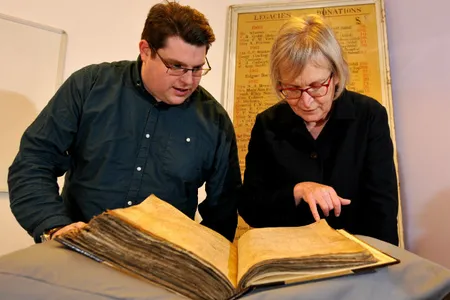 Gary Brannan, archivist, and Professor Sarah Rees Jones examine one of the archbishops' registers.

