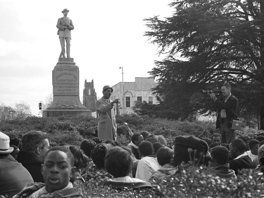 Tuskegee history professor Frank Toland speaks to the gathered students at the base of the Confederate monument