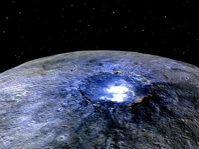 Occator Crater on Ceres, in false color, with the spots shining brightly. Blue is generally associated with bright material, found in more than 130 locations, and seems to be consistent with salts such as sulfates. The crater is 60 miles across.
