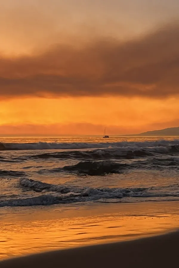 Orange Sunset - Lone Sailboat Navigates the Choppy Pacific Ocean thumbnail