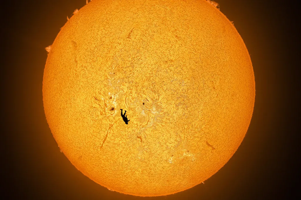 Black silhouette of upside-down person in front of the sun