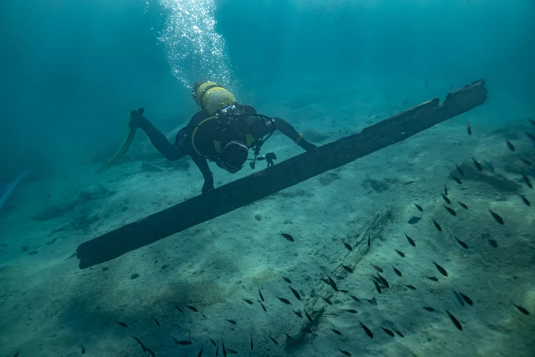 Archaeologist Xavier Aguelo Mas picks up a plank from one of the Busquets.