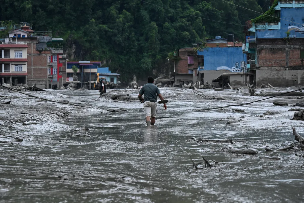 a man walking in a flooded village