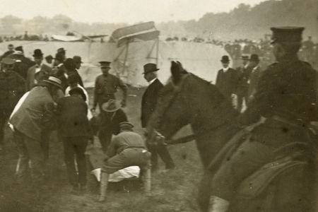 Bystanders crouch over Thomas Selfridge, pulled from the wrecked Wright Model A.