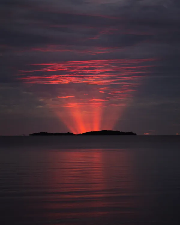 Red Crepuscular Rays from an Eclipse thumbnail