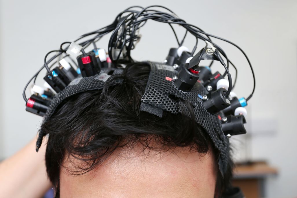 A man's head with many wires and electrodes attached to his scalp