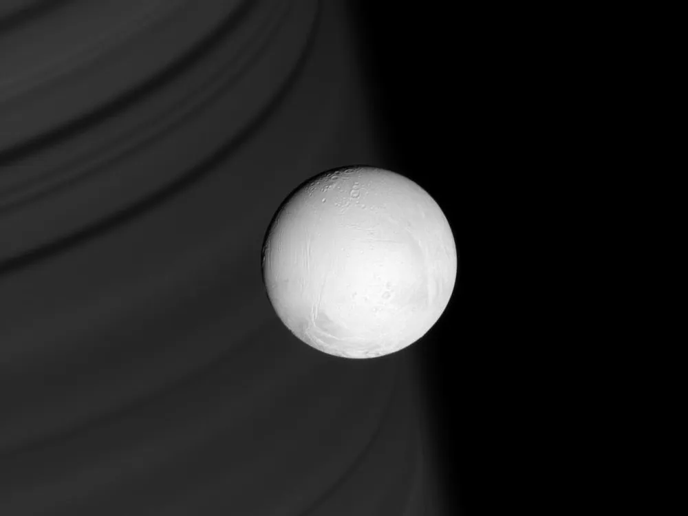 Saturn's white, icy moon Enceladus, with Saturn in the background
