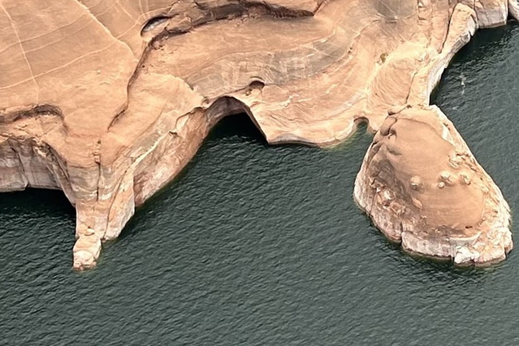 Aerial shot of sandstone rock on the edge of a body of water