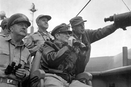 Brigadier General Courtney Whitney, government section, Far East Command; General Douglas MacArthur, Commander-in-Chief, United Nations Command, and Major General Edward Almond (at right, pointing), Commanding General, X Corps in Korea, observe the shelling of Incheon from the USS Mount McKinley.