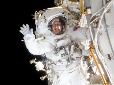 During a spacewalk on mission STS-131, astronaut and author Clay Anderson, hanging from the space station, waved to his shuttle Discovery crewmates.