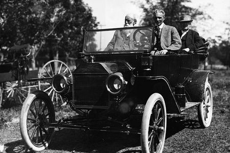 Henry Ford is at the wheel with John Burroughs and Thomas Edison seated in the back of a Model T.
