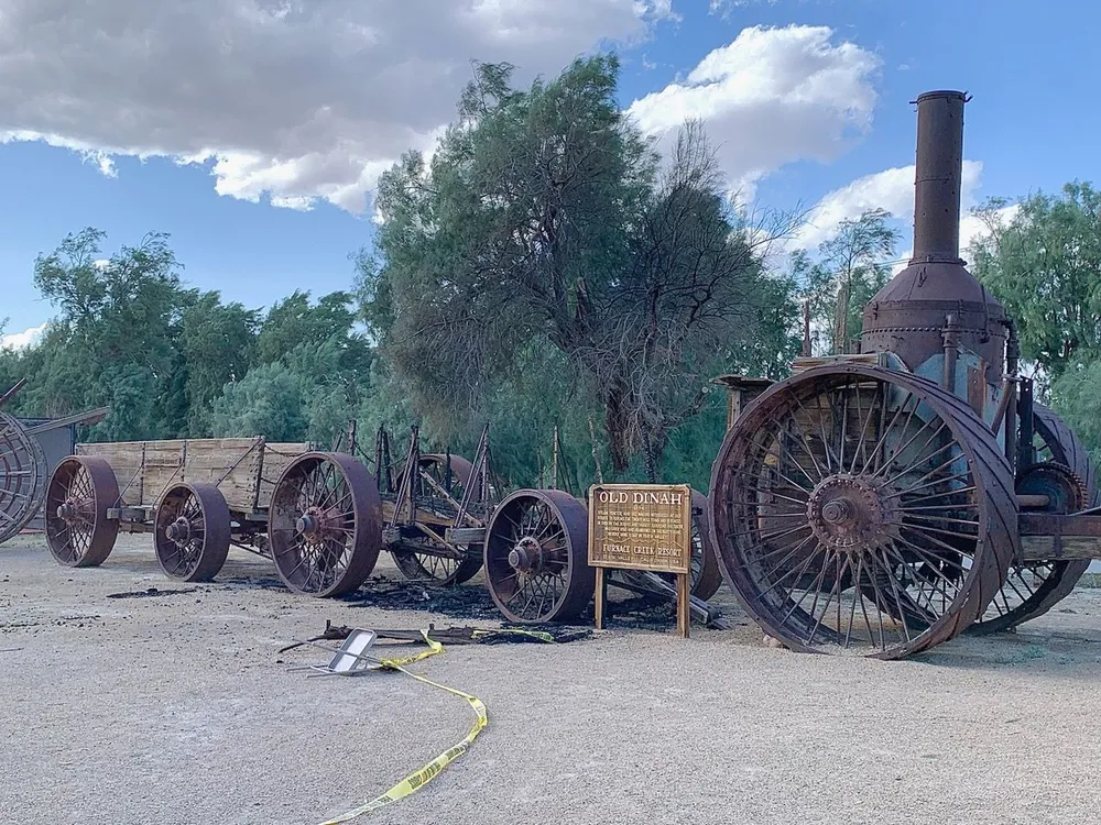 Burned wagon next to steam engine