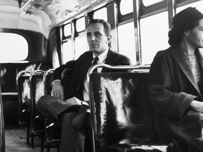 For a photo op, Rosa Parks sits in the front of a bus on December 21, 1956, the day that Montgomery's buses were officially integrated.