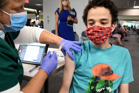 A nurse gives a 16-year-old a Pfizer-BioNTech shot at a clinic in Florida.