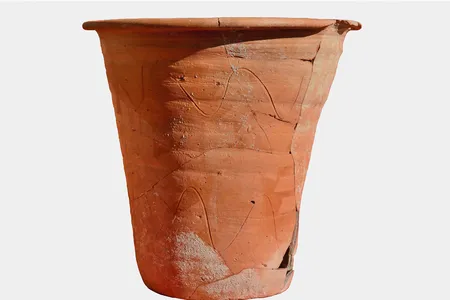 The chamber pot stands about 12.5 inches tall and measures 13.5 inches wide at the rim.