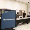 A sign says Registration and a group of people approach a table