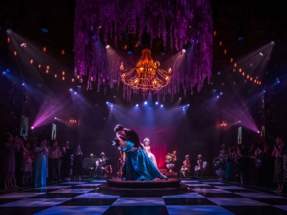 couple in Regency attire doing a dip in the middle of a dramatically lit ballroom