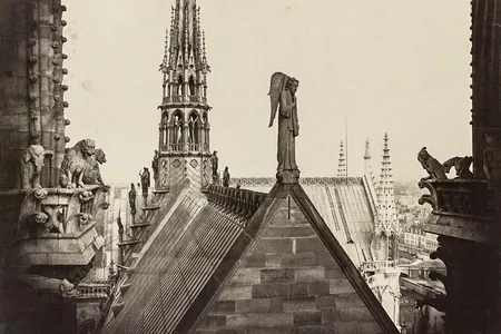 A rooftop view with gargoyles on the left and other statuary, circa 1860.