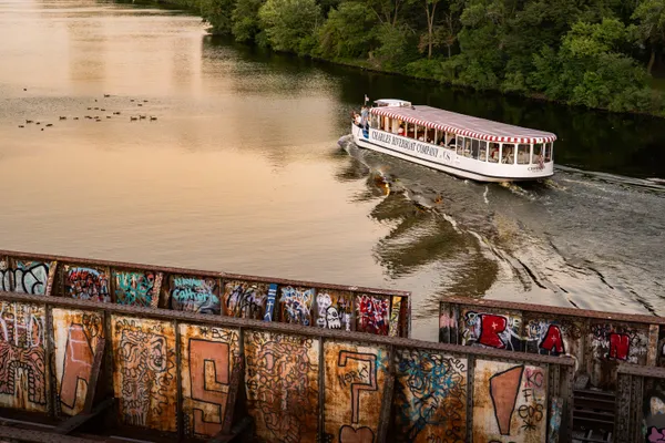 A boat driving through the Charles River in the sunset thumbnail
