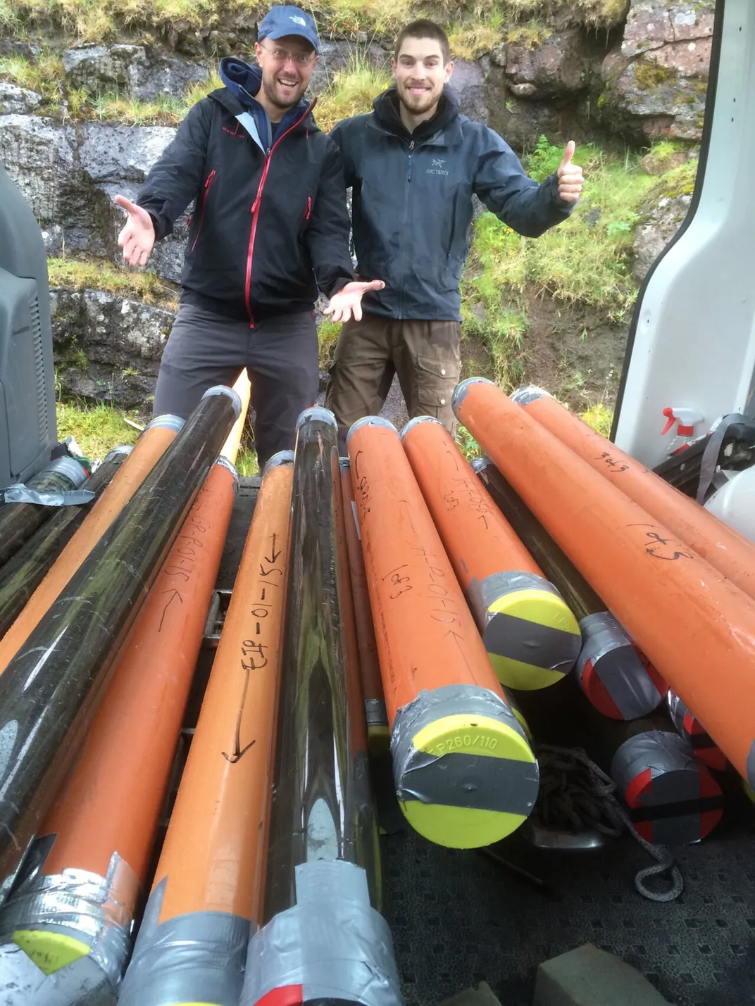 two researchers pose with sediment cores