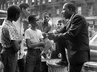 Civil Rights activist Grady O'Cummings talking with a group of boys. O'Cummings later faked his own death to avoid threats made by members of the Black Panthers against him and his family.