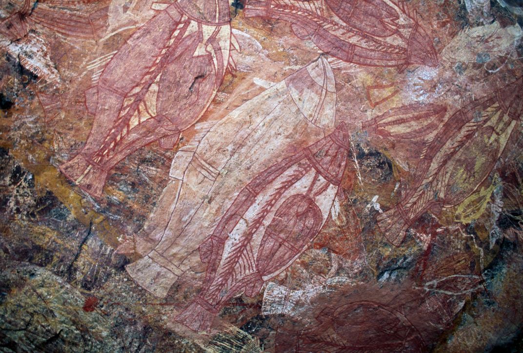 Red and white cave painting depicting animals