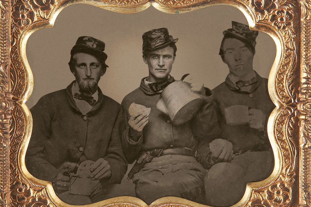 Union soldiers sit will coffee and bread in a portrait