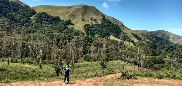 A boy enjoying the beautiful view of mountains thumbnail