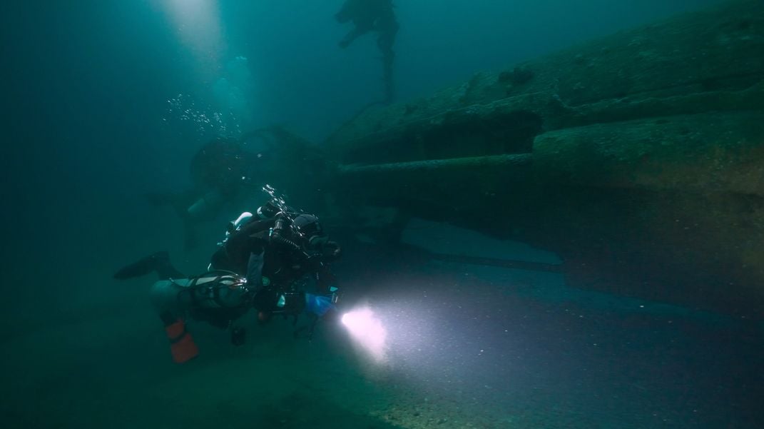 Diver Nathan Martel inspects the stern of the wreck of UC-18​​​​​​​.