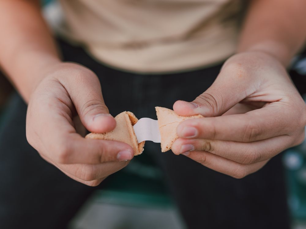 Close-up shot of person opening a fortune cookie