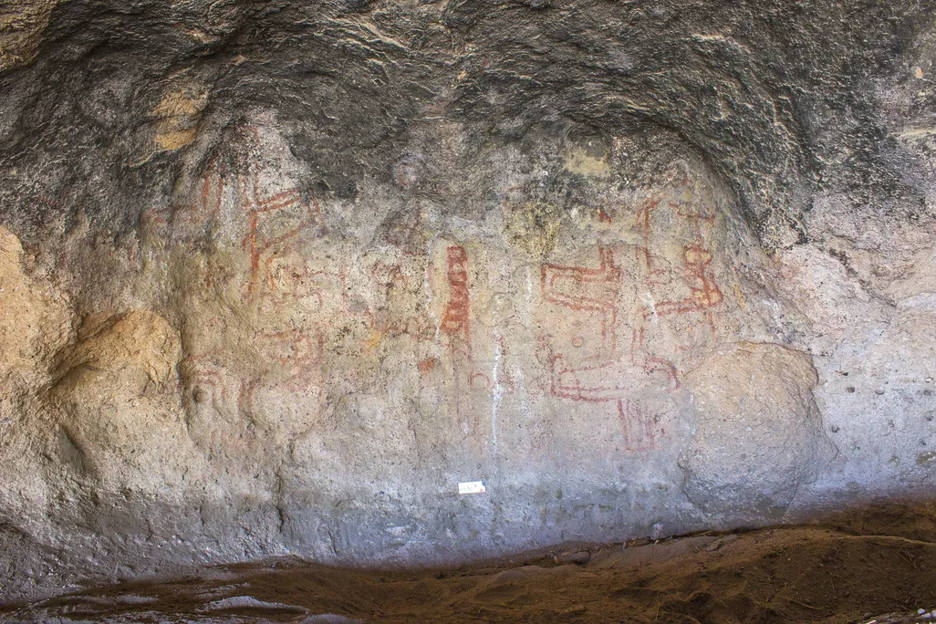 Red geometric drawings on a cave wall
