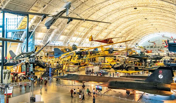 The Boeing Aviation Hangar at the Steven F. Udvar-Hazy Center is a vast open space filled with airplanes on both the floor and hanging from the ceiling, tilted at angles that convey the impression of flight.