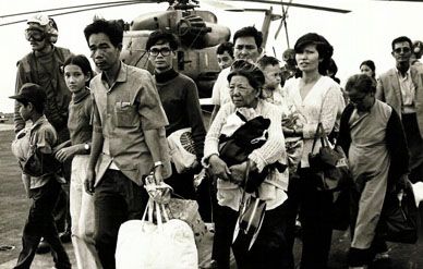 South Vietnamese refugees walk across a U.S. Navy vessel after fleeing their homes in April 1975.