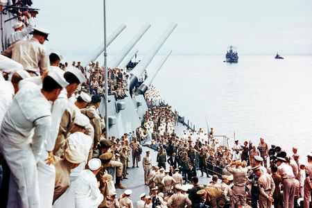 Sailors aboard the USS Missouri watch as dignitaries correct an error on the Japanese copy of the Instrument of Surrender. Many of the sailors had spent days cleaning and readying the ship for the pageant that 75 cameramen recorded for history.