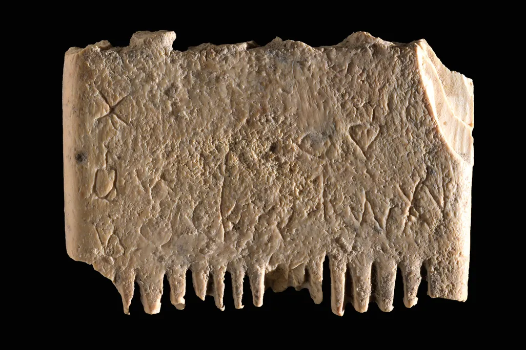 an ancient marble comb sits on a black backdrop