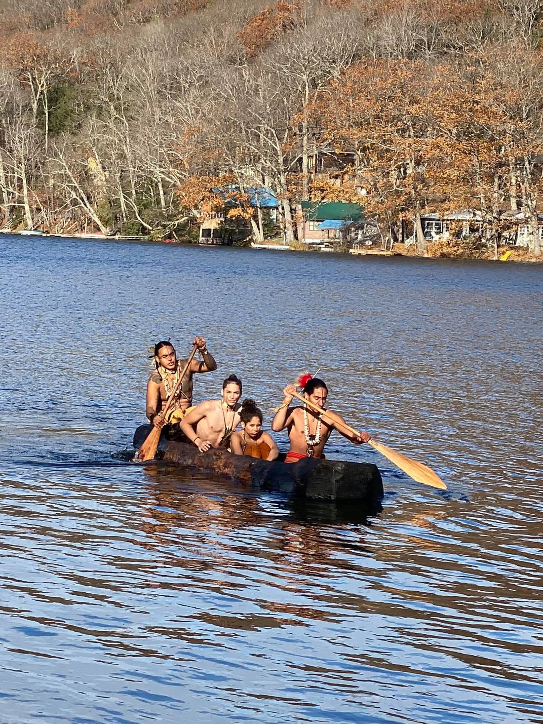 Nipmuc tribal members paddling a mishoon in their traditional territory in Massachusetts.