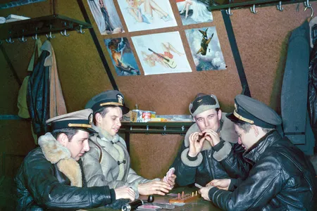 Some photos show intimate moments: At a remote base in the Aleutian Islands, U.S. Navy aircrew amuse themselves with cribbage—and posters of pin-up girls.
