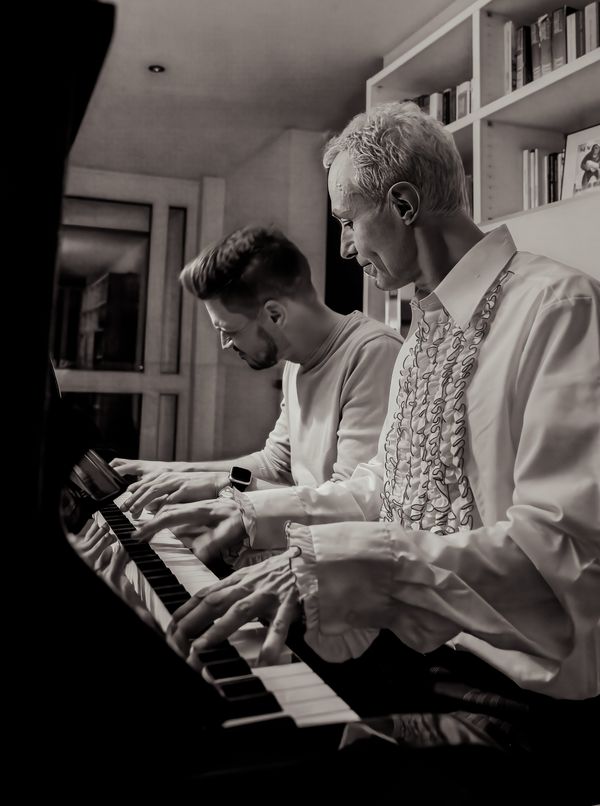 Two friends playing the piano together thumbnail