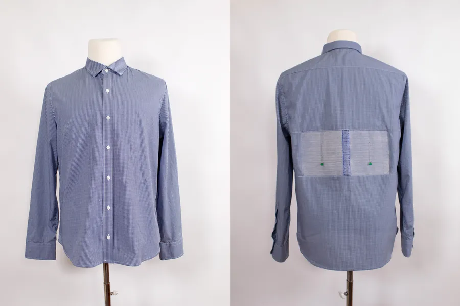 The front and back view of a button-down shirt. The back shows two sewn-in panels