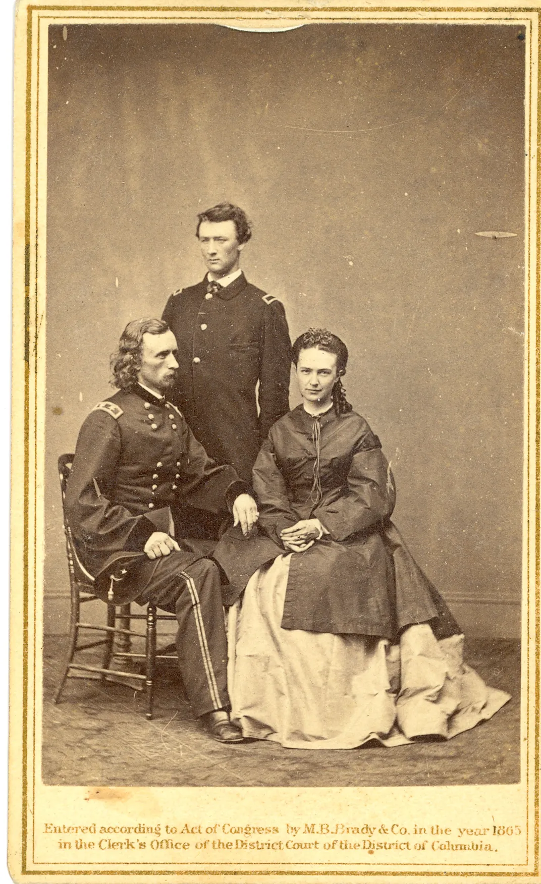 A studio portrait of Custer; his brother Thomas Ward Custer; and his wife, Elizabeth Custer