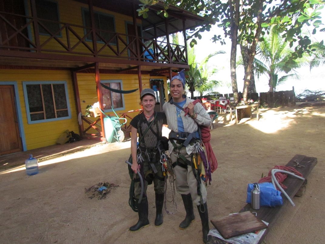 Conservation biologists Tremaine Gregory (left) and Farah Carrasco Rueda (right) pose for a photo in their climbing gear outside of a building in Panama during a tree-climbing course.