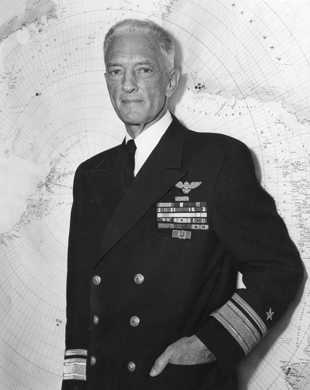 Richard Byrd poses in front of a map of Antarctica on March 15, 1956