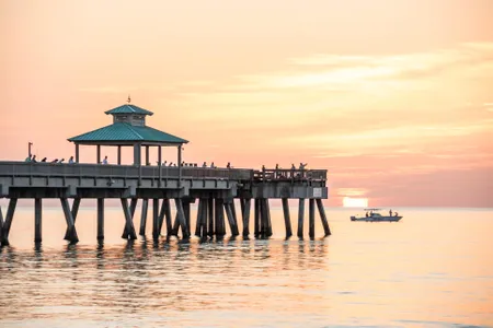 Deerfield Beach Pier with fisherman at dawn.