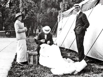 Glenn Martin (standing). By 1913 Martin was taking credit for Broadwick’s invention, and the following year he patented it. Here, he and Tiny watch Broadwick stitch up the canopy of a parachute.