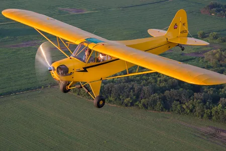 Jessica Voruda and a passenger fly in a Piper J3C Cub over farmland near Hartford, Wisconsin in July, 2017.