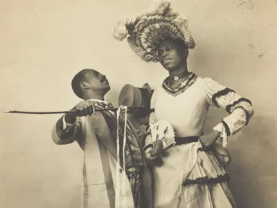 No known photographs of Swann survive. This 1903 postcard depicts two Black actors, one of whom is dressed in drag, performing a cakewalk in Paris.